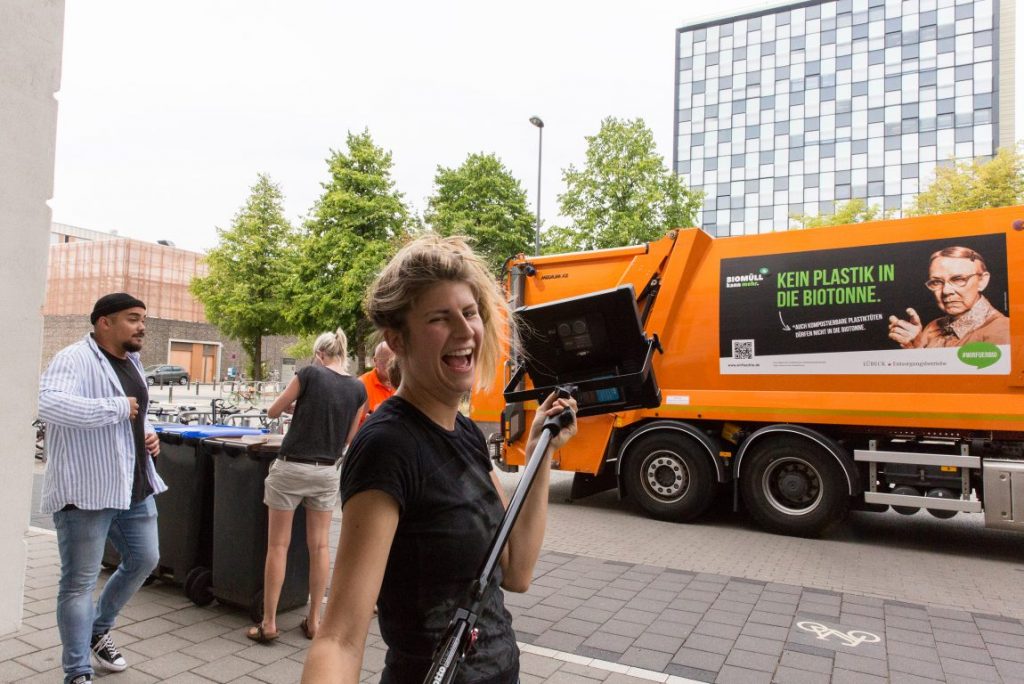Frau vor Müllfahrzeug mit Kampagnenbrandig