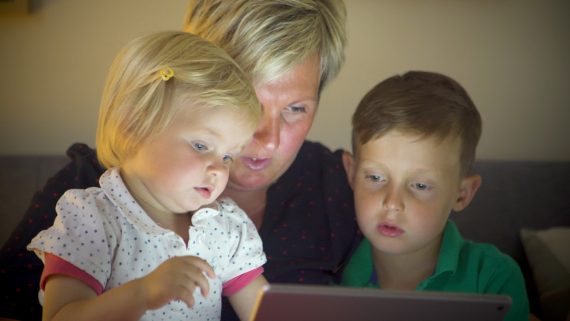 Frau und Kinder betrachten Laptop-Display