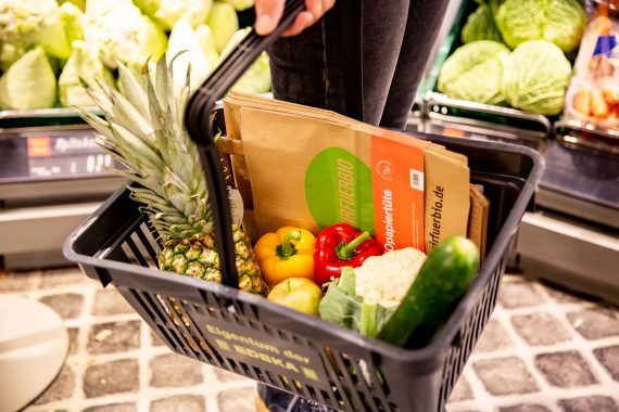 Einkaufskorb mit Obst, Gemüse und #wirfuerbio-Papiertüten
