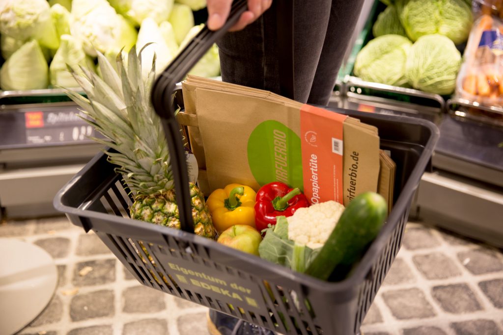 Einkaufskorb mit Obst, Gemüse und #wirfuerbio-Papiertüten